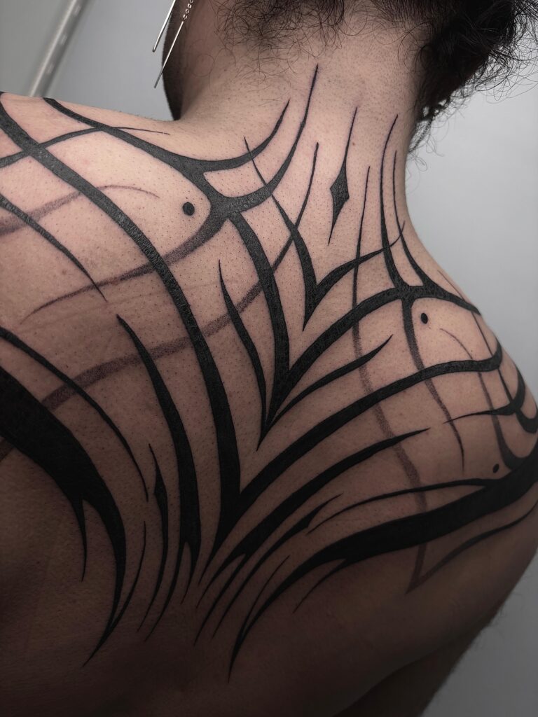 Tatuaje blackwork de líneas en espalda y cuello hecho en Three Lines, estudio de tatuajes en Bilbao