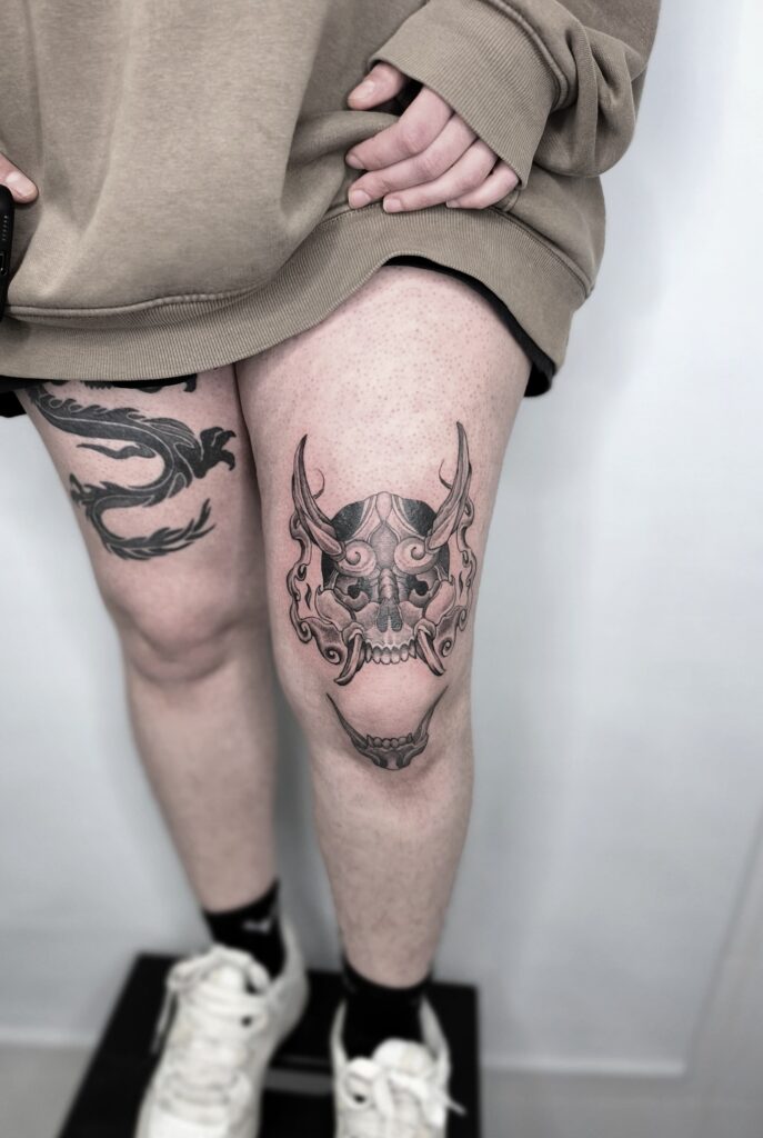 Tatuajes de dragón oriental y máscara hannya en las piernas