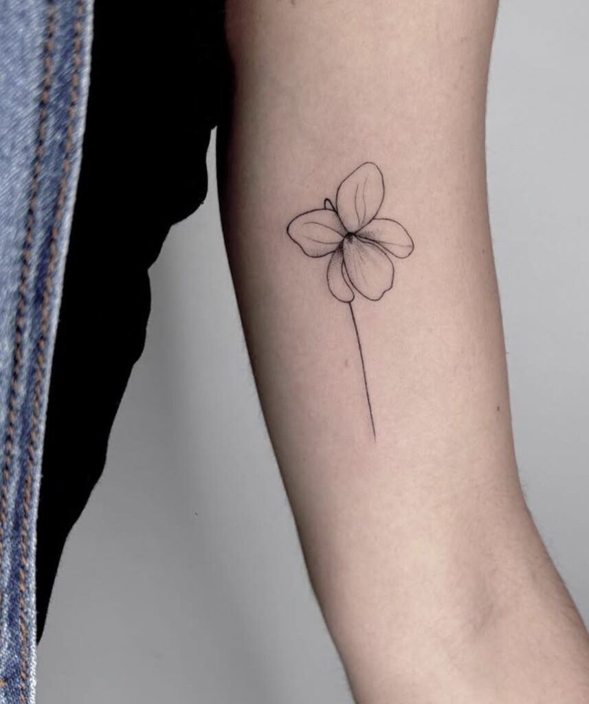 Tatuaje fineline de flor en el brazo en Bilbao