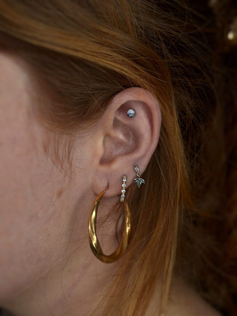 Piercings en la oreja con joyería de titanio y oro