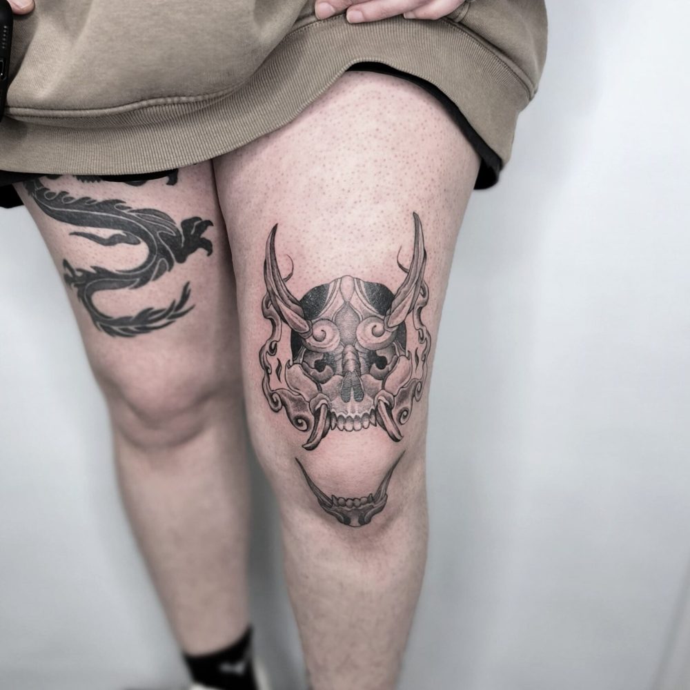 Tatuajes de dragón oriental y máscara hannya en las piernas en Bilbao